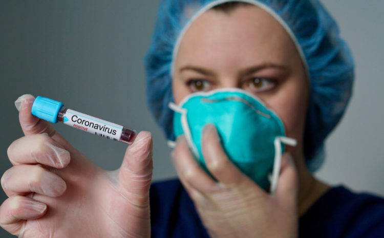 featured image Nurse wearing respirator mask holding a positive blood test result for the new rapidly spreading Coronavirus, originating in Wuhan, China