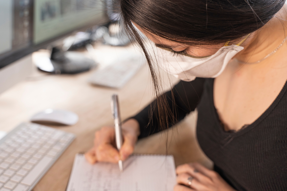featured image showing a woman in the office wearing a mask