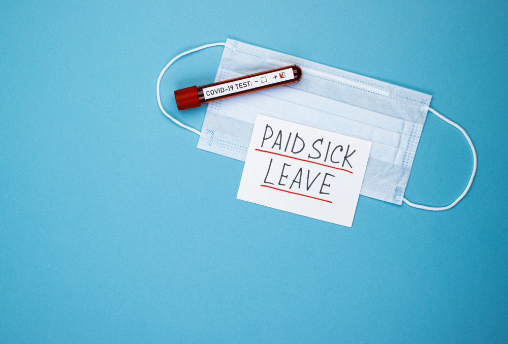 featured image showing a COVID-19 test , mask and a note stating Paid Sick Leave