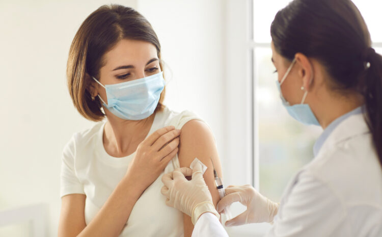 featured image showing Professional woman getting a COVID-19 Vaccine While Wearing a Face Mask