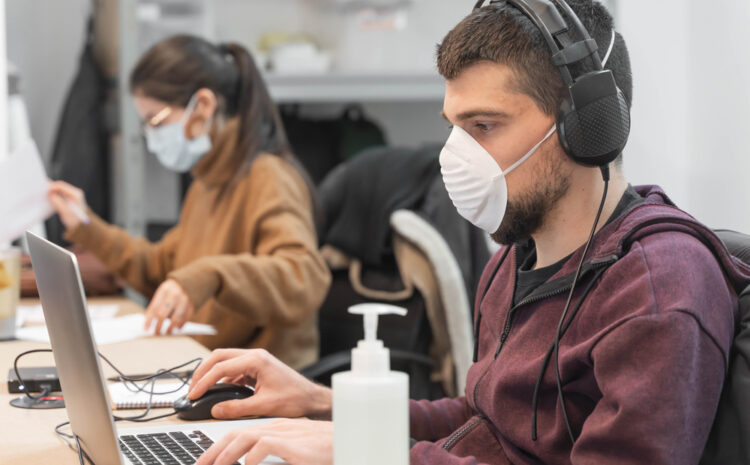 featured image showing employees wearing masks, working 6 feet apart with access to hand sanitizer